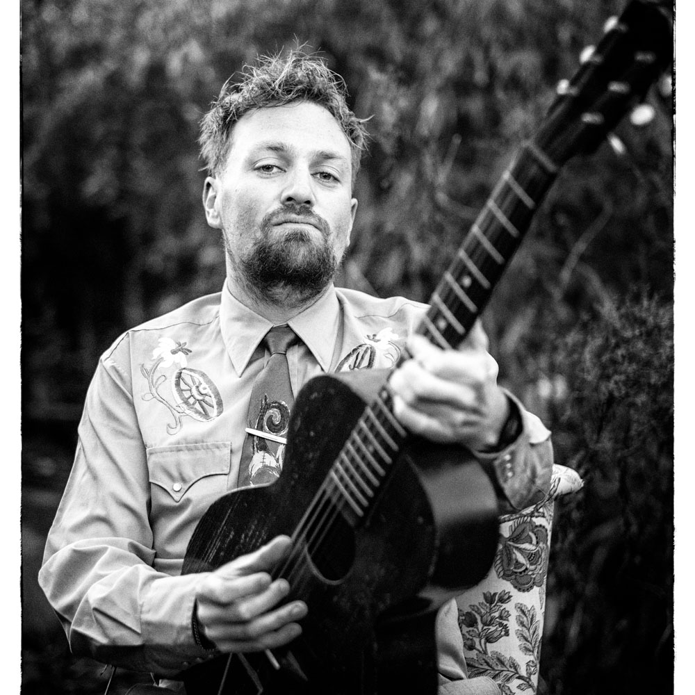Zwart witte foto van Tim Knol met een gitaar