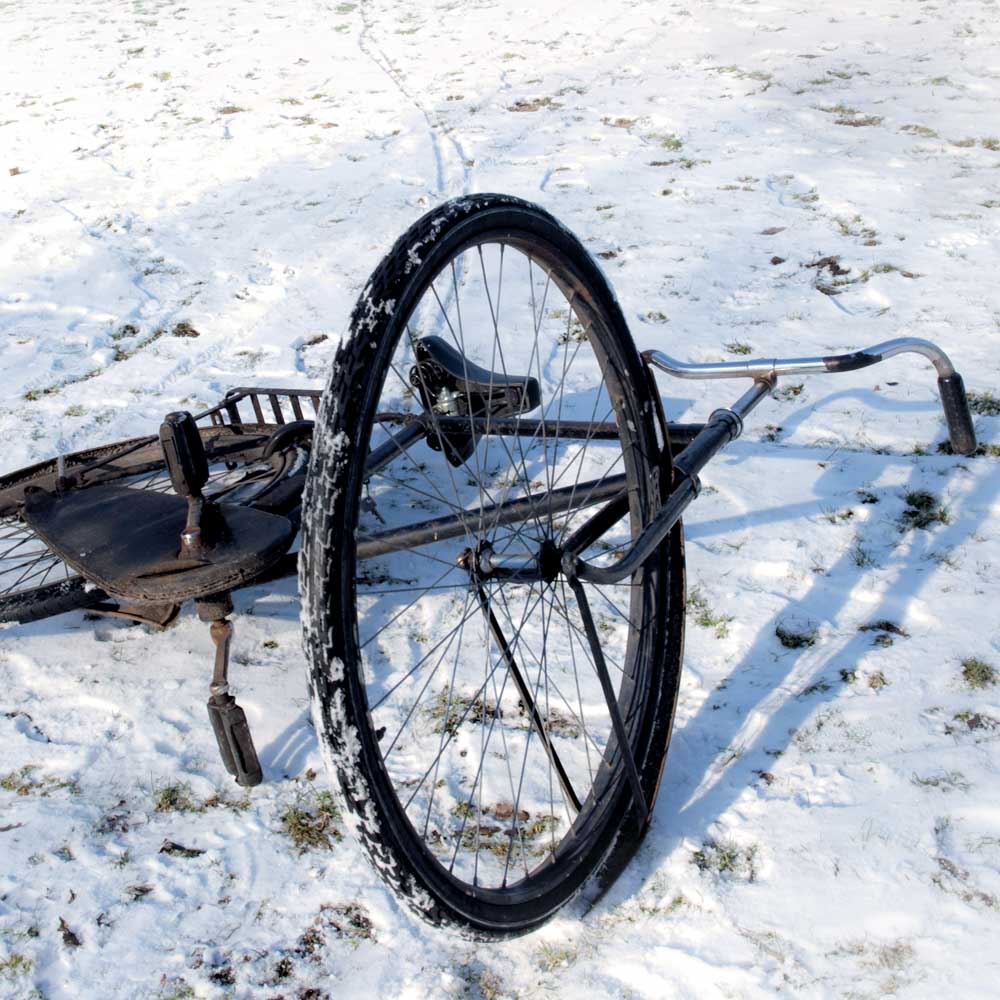 Voorstellingsbeeld van de Aanslag: omgevallen fiets in de sneeuw, met sporen van de banden die in de sneeuw achterblijven.
