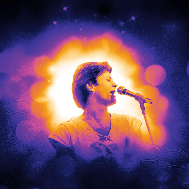 Een gepassioneerde zanger, omhuld door een aura van paars en oranje licht met fonkelende sterren, verliest zich volledig in de muziek op het podium.