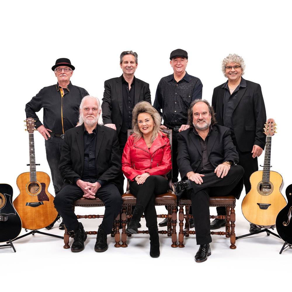 Artiesten van Back to the Country poseren met gitaren voor een groepsfoto.