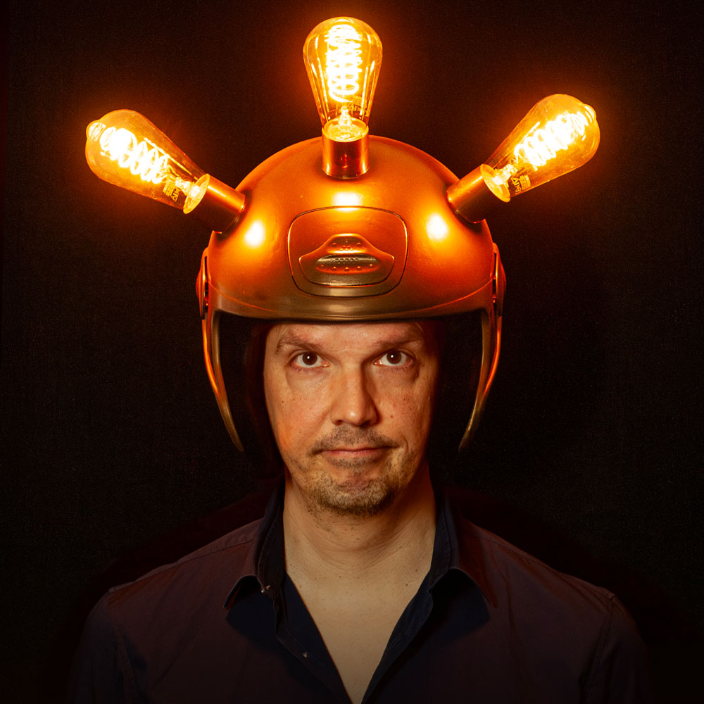Peter van Ewijk draagt een helm met lichtgevende gloeilampen in donkere setting.