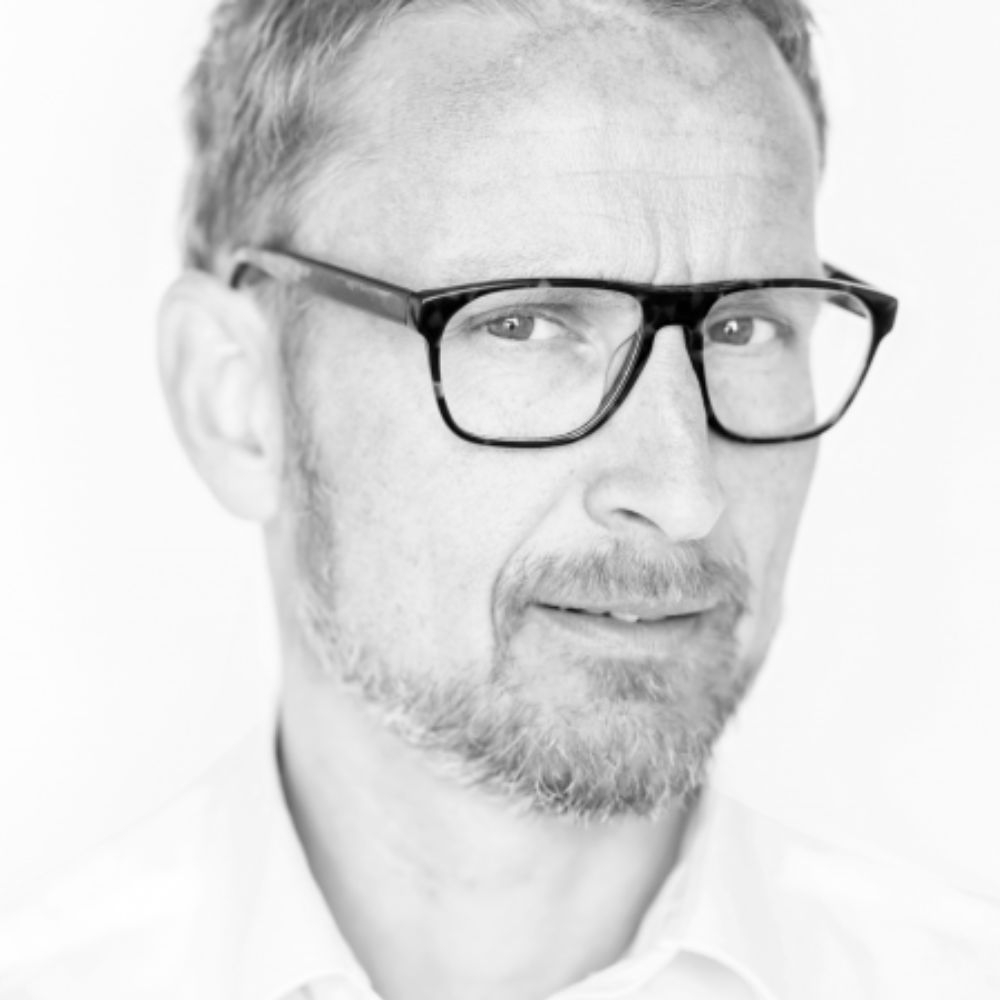 Voorstellingsbeeld van Pieter Jouke met bril in zwart-wit fotografie, met een serieuze blik.