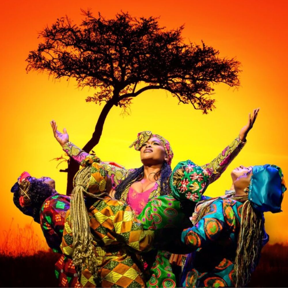 Voorstellingsbeeld van The African Mamas in kleurrijke traditionele kostuums tegen een Afrikaanse zonsondergang.
