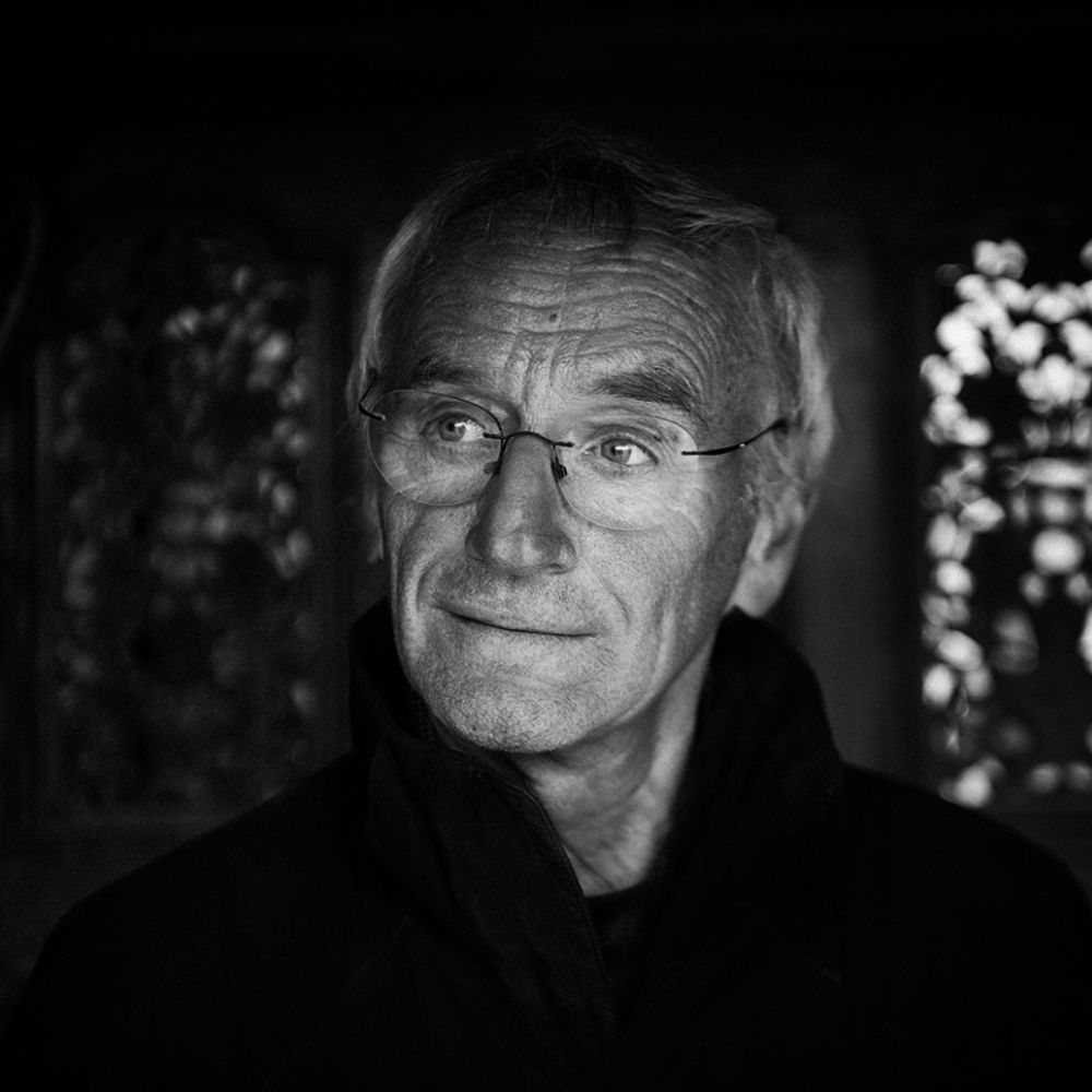 Portret van Karel de Rooij in zwart-wit, met rustige en bedachtzame blik.