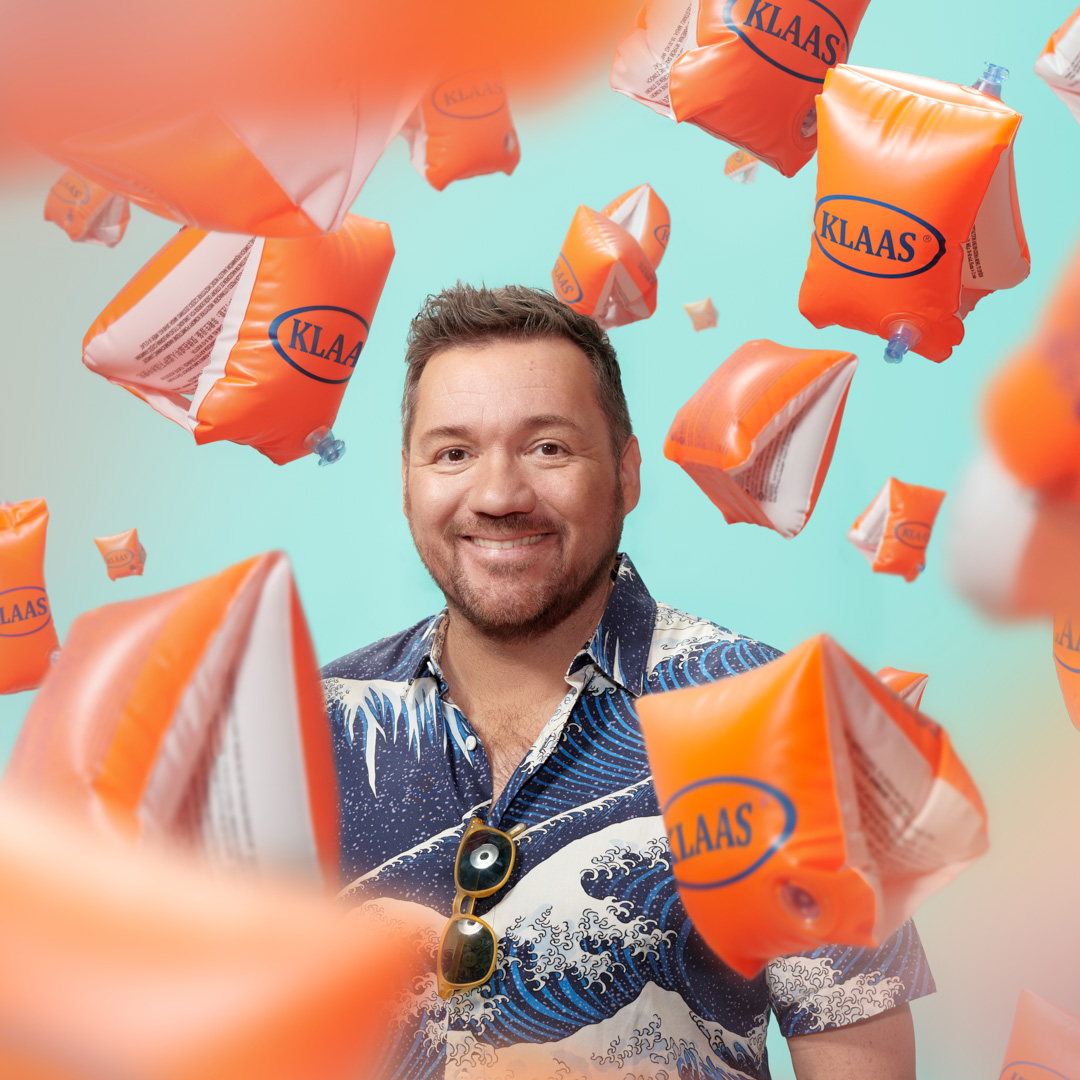 Klaas van der Eerden lacht tussen zwembandjes met zijn naam erop.