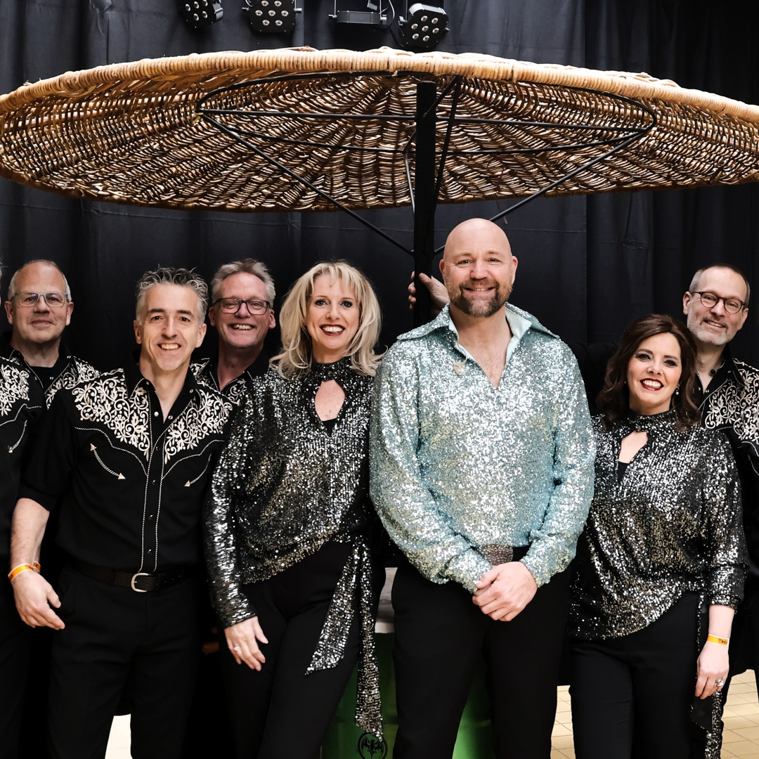 Groepsfoto van muzikanten van Neil Diamond Memories in glitterkleding voor de Sweet Caroline Tour.