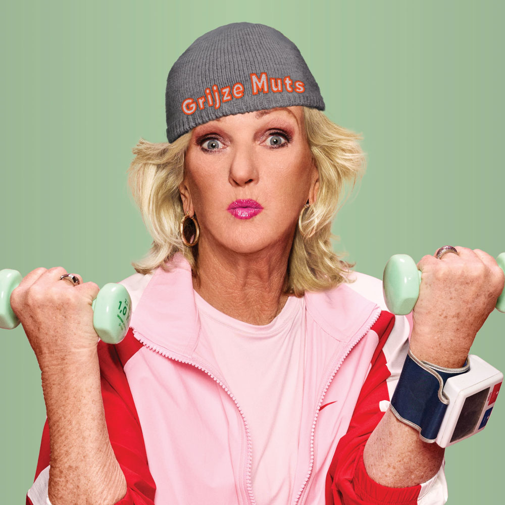 Tineke Schouten in sportoutfit tilt gewichten met grijze muts en felle blik.