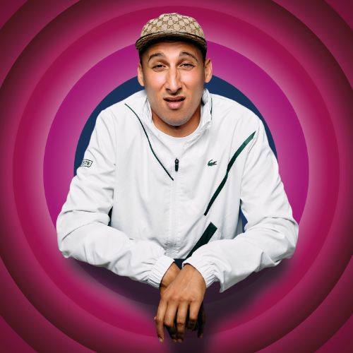 Jawad es Soufi kijkt verbaasd met zijn armen op tafel tegen kleurrijke cirkelachtergrond.