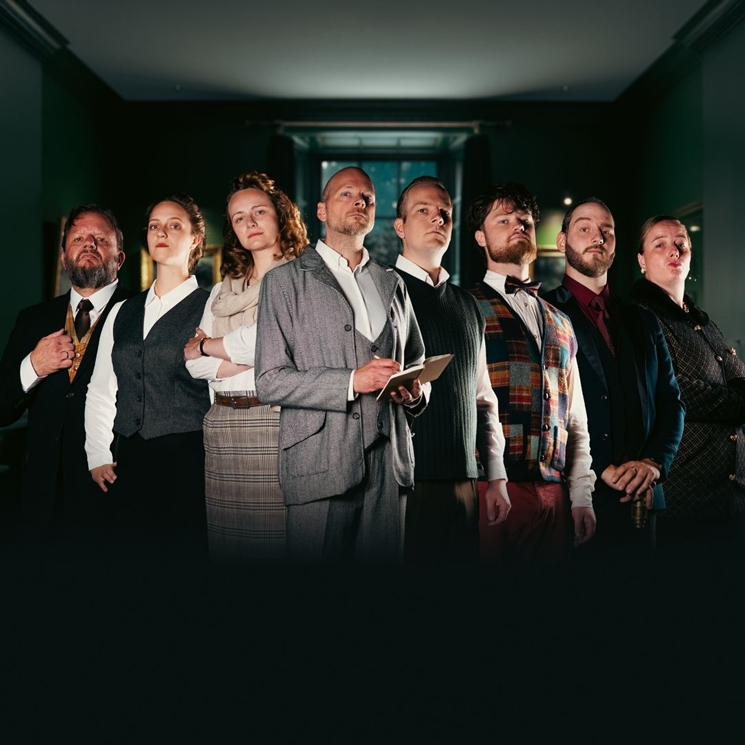 Cast van The Mousetrap poseert in retro kleding in een donker interieur.