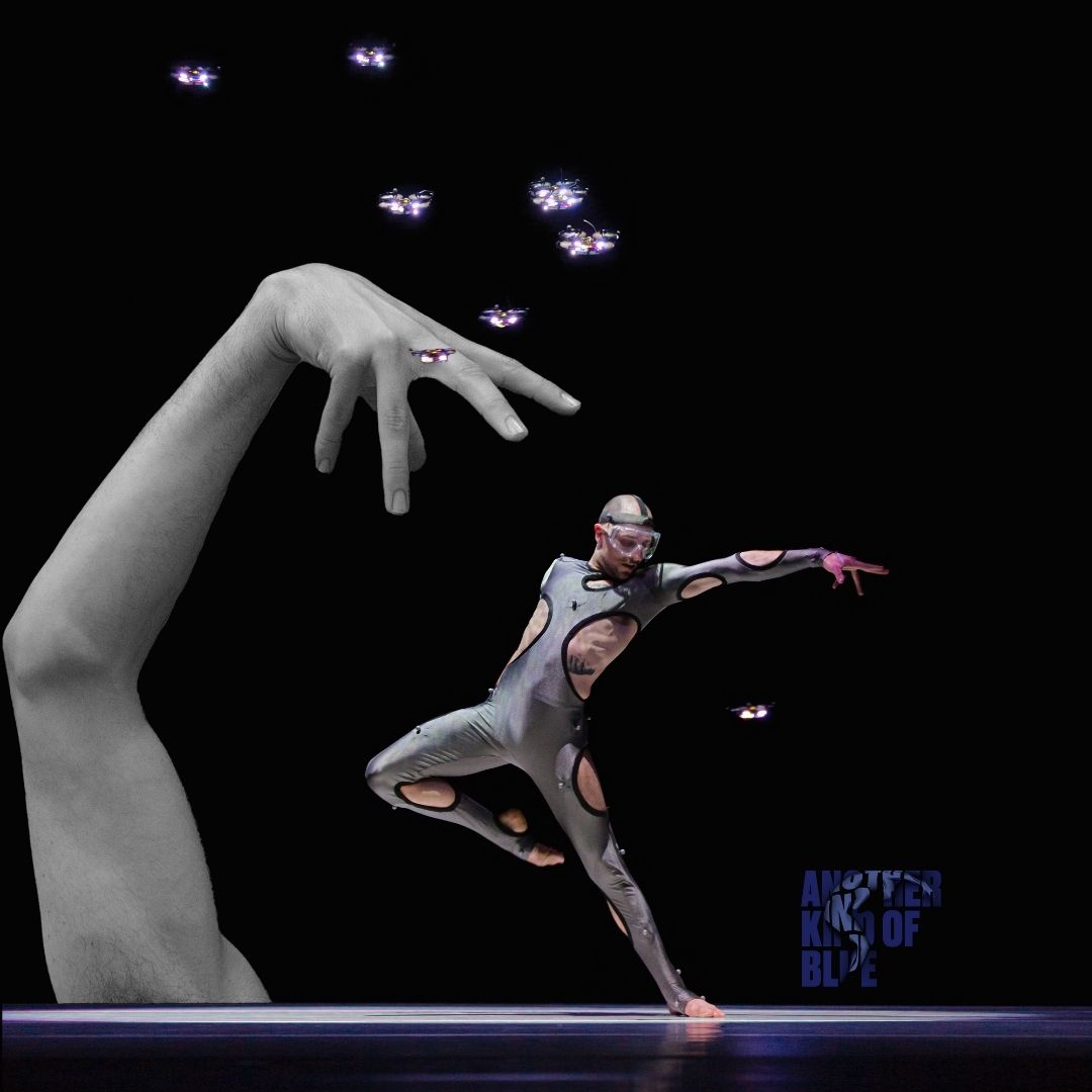 Danser in futuristisch pak buigt voorover met gestrekte arm, omringd door kleine drones.