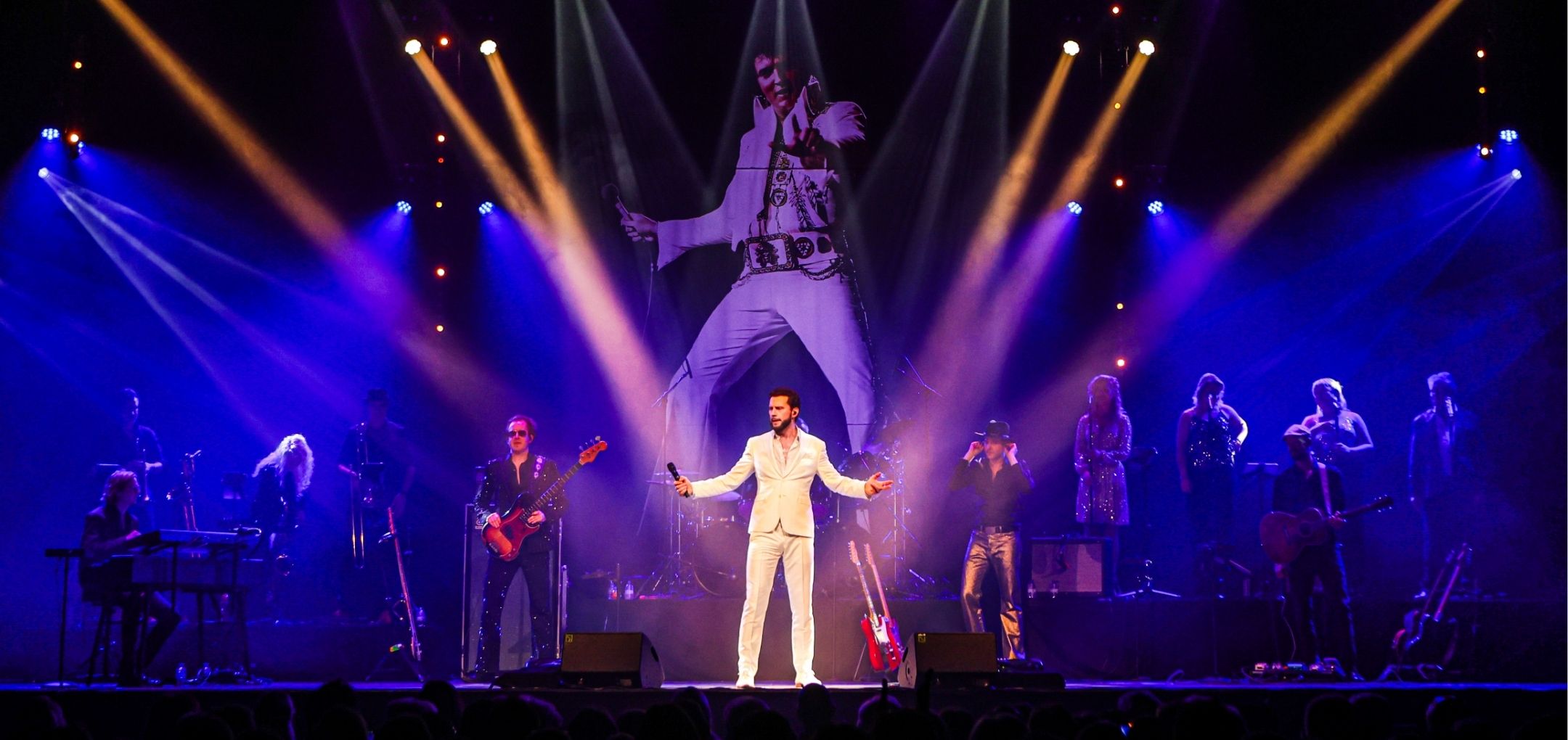 Bouke staat zingend op het podium met Elvis-silhouet op de achtergrond.