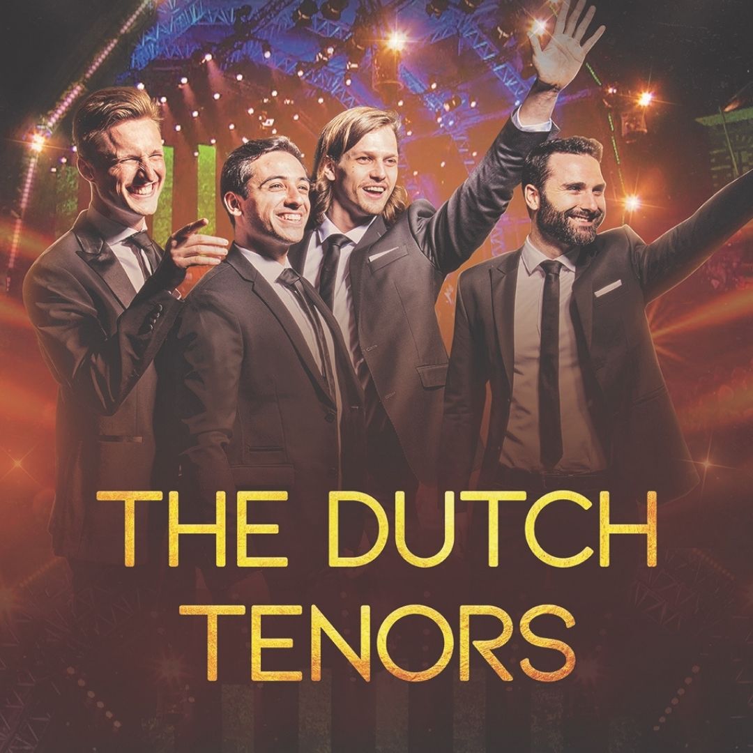 The Dutch Tenors poseren in kostuum onder theaterlicht met een glimlach.