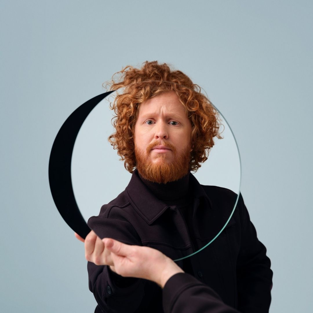 Kasper van der Laan kijkt door een ronde glazen schijf die hij voor zich houdt.