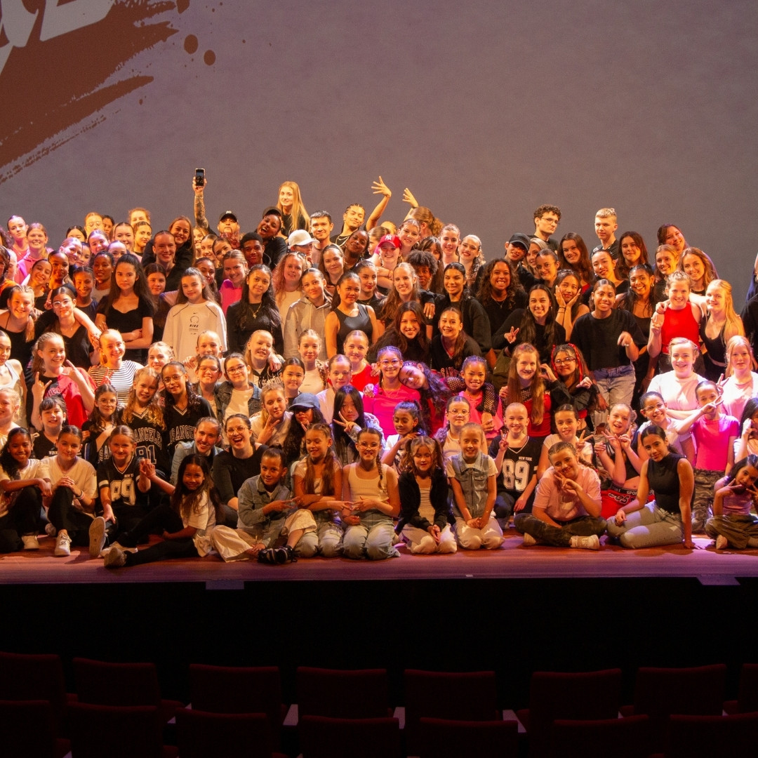 Dansgroep van Kick 'N Studios juichend op het podium.