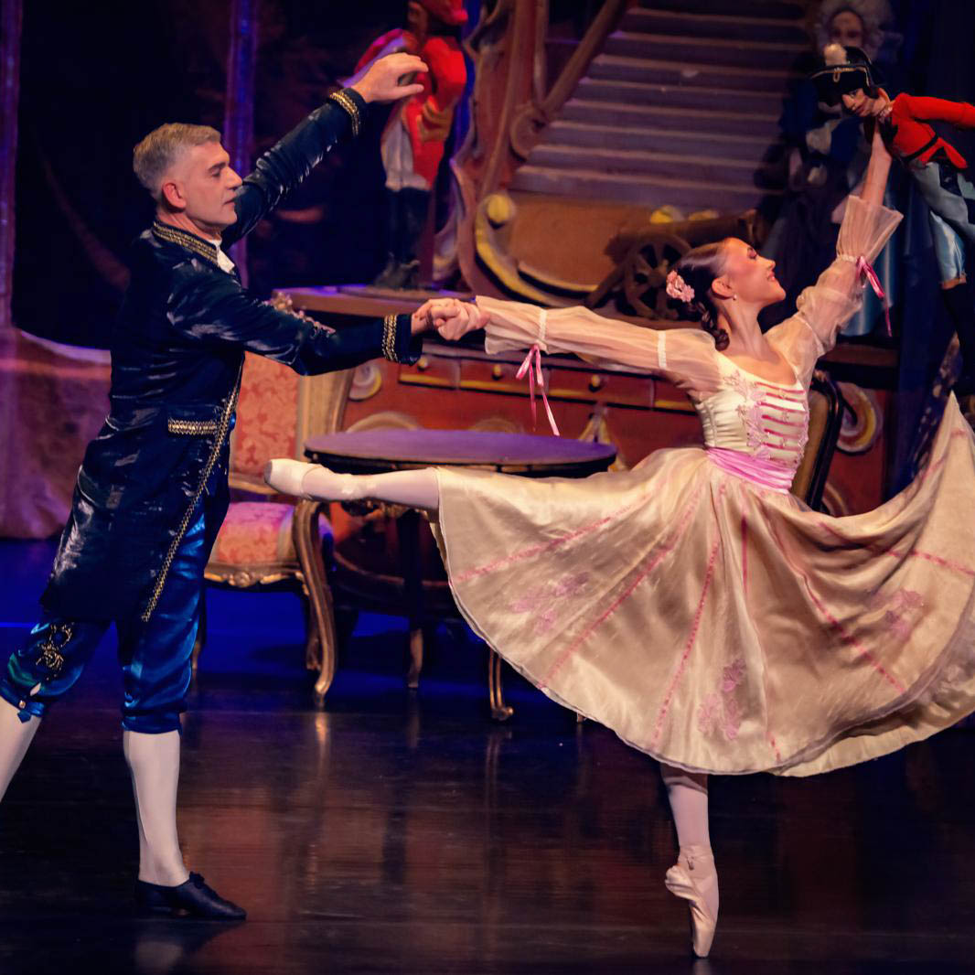 Ballerina danst in roze tutu op podium in ballet De Notenkraker.