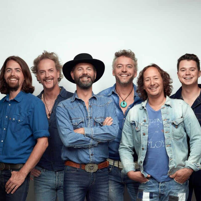 Vier bandleden van Dutch Eagles in denim voor witte achtergrond in Eagles tribute.