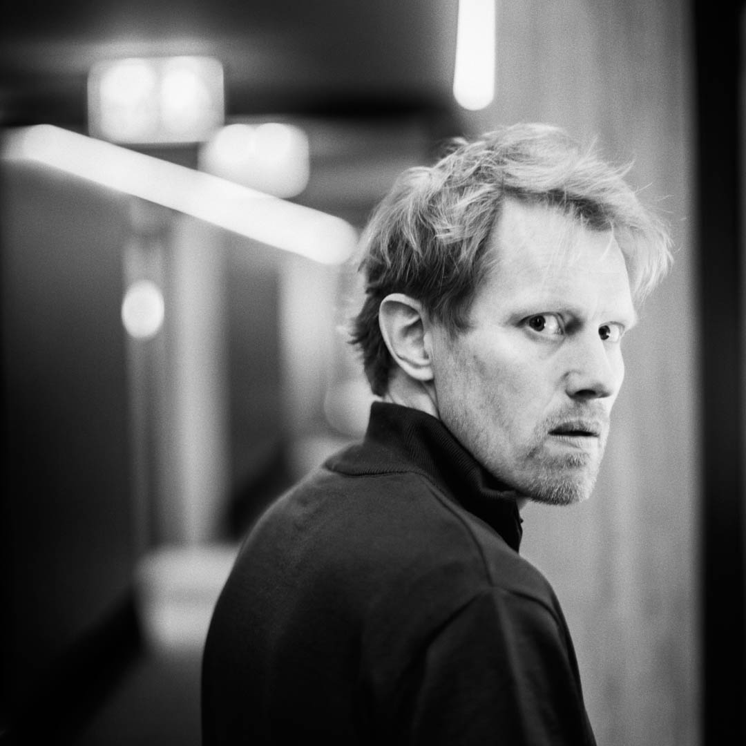 Jan Beuving in donkere trui onder spotlight in cabaretvoorstelling Depkunt.