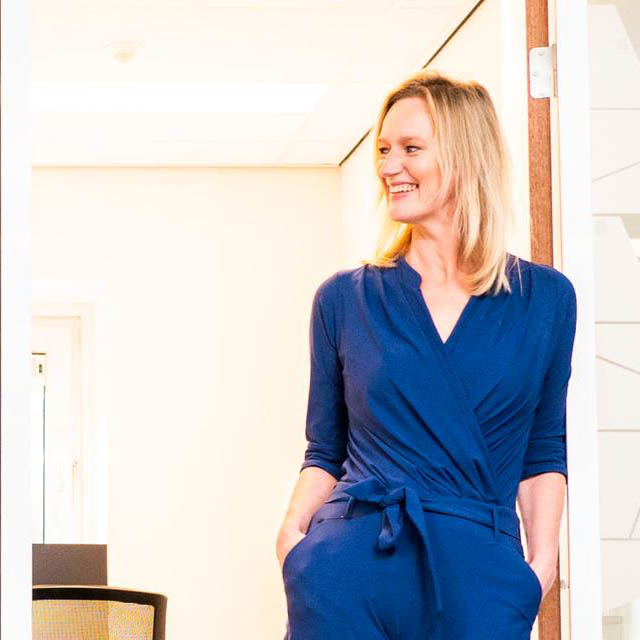 Japke-d. Bouma in blauwe jurk voor heldere achtergrond in theatershow Japke-d. Bouma.