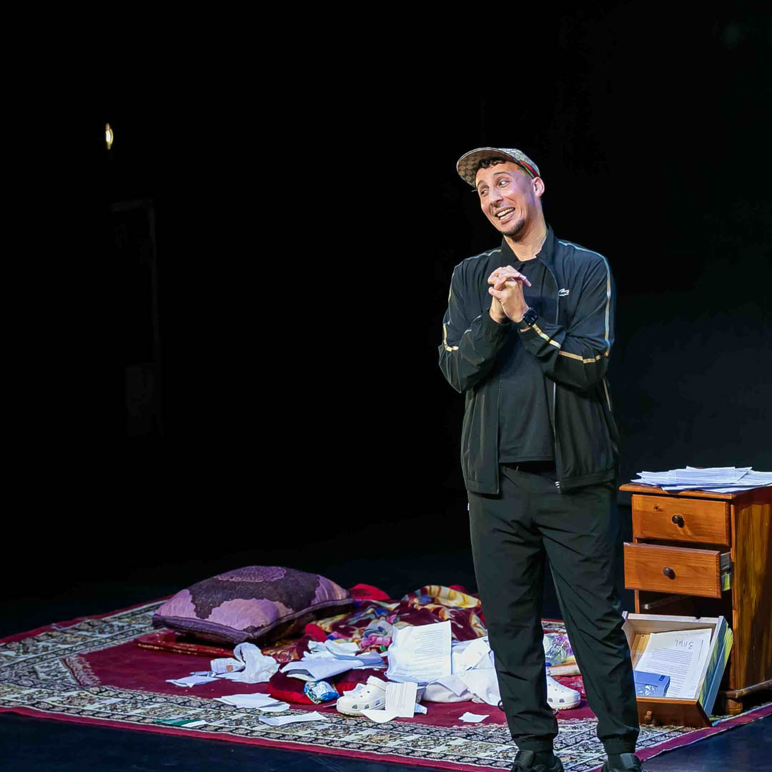 Jawad Es Soufi met microfoon op leeg podium in cabaretvoorstelling Jawad Es Soufi.