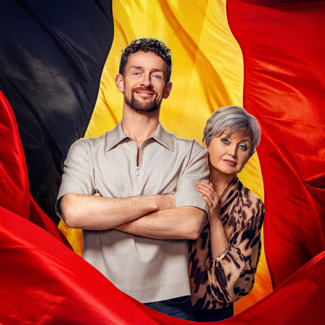 Spelers poseren samen in Nederland/België voor grote vlaggen van beide landen.
