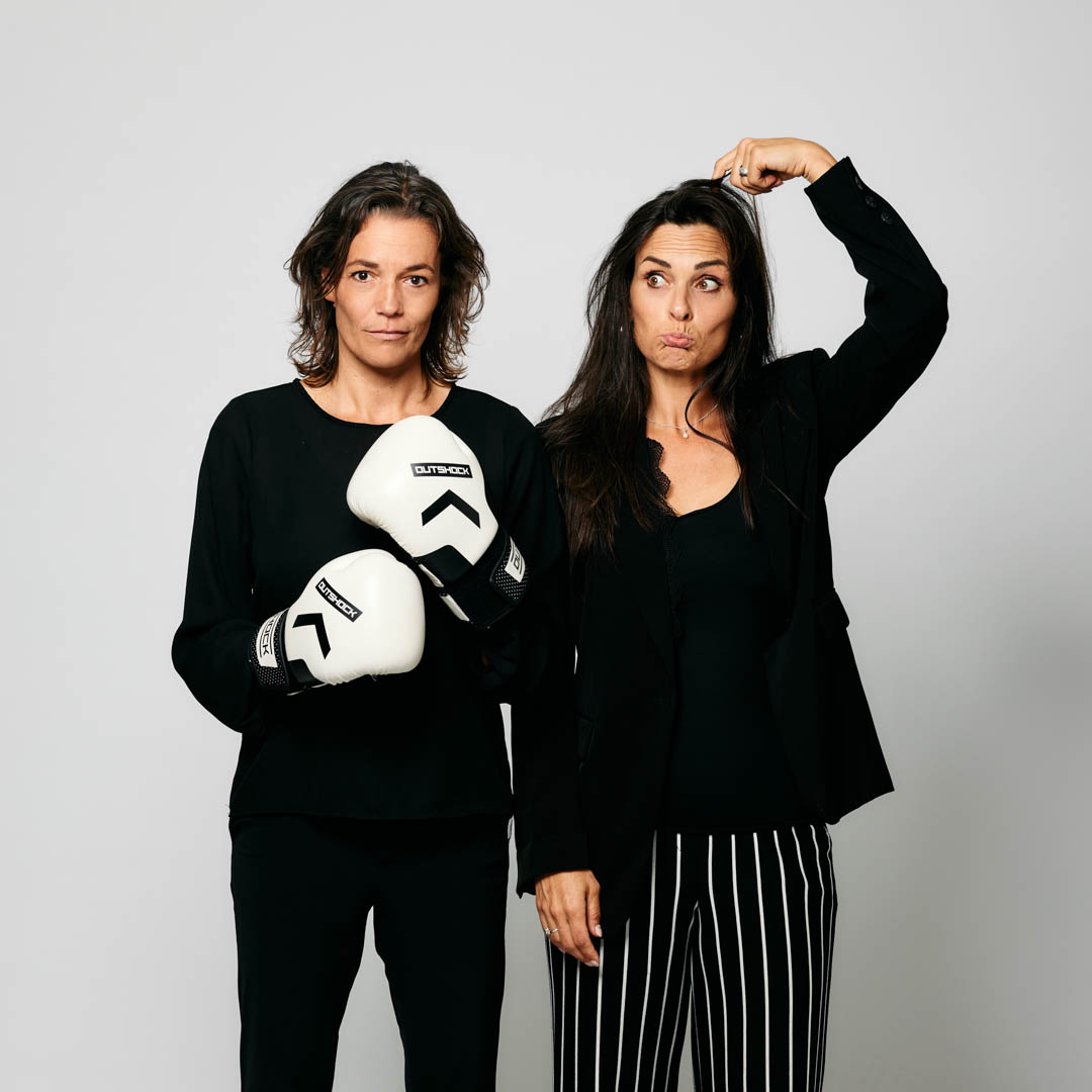 Ilse van den Heuvel en Marieke van Ginneken staan naast elkaar in Opvoeden, hoe dan…!? met speelse houding.