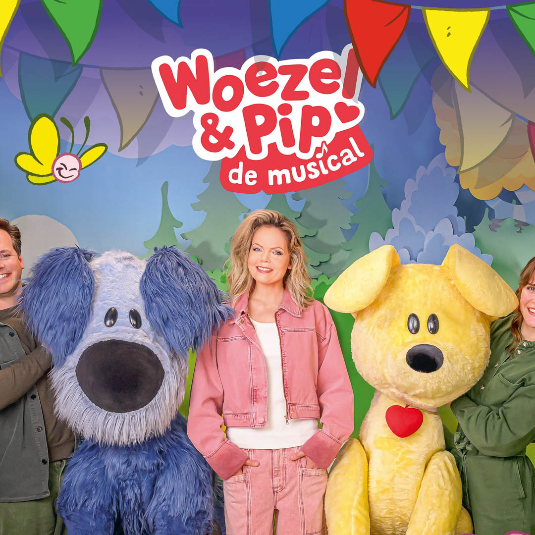 Woezel en Pip staan naast vrouw op kleurrijk decor in Woezel en Pip De Musical.