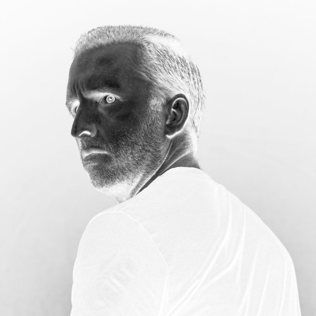 Peter kijkt over zijn schouder naar de camera in een contrastrijk negatief portret voor Demonen.